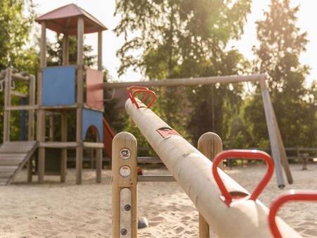 Klettergerät und Wippe auf einem Spielplatz im Ferienpark Landal De Vlegge