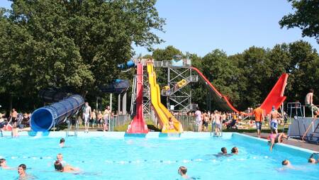 Verschiedene große Rutschen im Außenpool des Ferienparks Molecaten Bosbad Hoeven