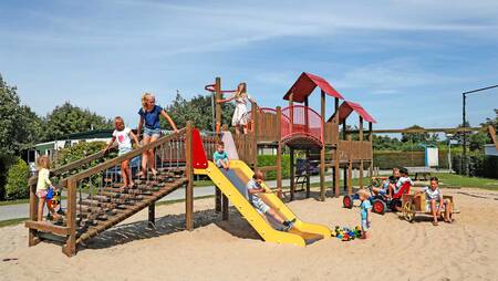 Kinder spielen auf einem Spielplatz im Ferienpark Molecaten Hoogduin