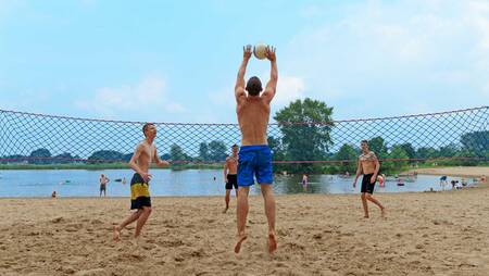 Leute spielen Volleyball am Strand des Ferienparks Molecaten Park De Agnietenberg