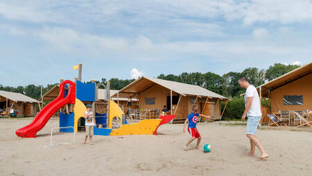 Safarizelte rund um einen Spielplatz im Ferienpark Molecaten Park Flevostrand