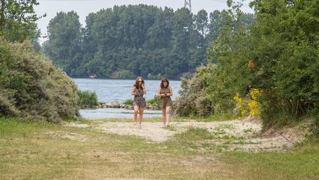 Zwei Frauen gehen am Brielse Meer im Ferienpark Molecaten Park Kruininger Gors spazieren
