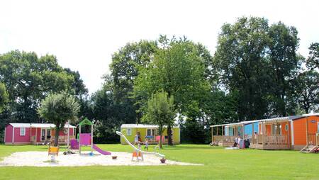 Chalets auf einem Feld mit Spielplatz im Ferienpark Molecaten Park Kuierpad