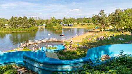 Menschen auf der Außenrutsche, die im Ferienpark Molecaten Park Kuierpad im See endet