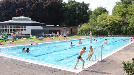 Menschen schwimmen im Außenpool des Ferienparks Molecaten Park Landgoed Ginkelduin