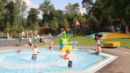 Kinder spielen draußen im Planschbecken des Ferienparks Molecaten Park Landgoed Ginkelduin