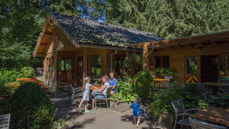 Familie auf der Terrasse der Kantine des kleinen Ferienparks Park Landgoed Molecaten