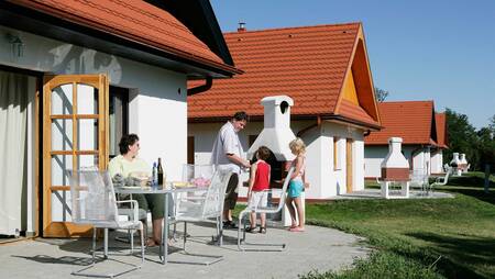 Menschen im Garten eines Ferienhauses im Ferienpark Molecaten Park Legénd Estate