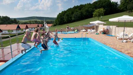 Kinder springen in den Außenpool des Ferienparks Molecaten Park Legénd Estate