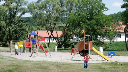 Kinder spielen auf dem Spielplatz des kleinen Ferienparks Molecaten Park Legénd Estate