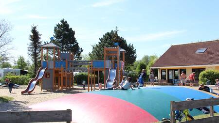 Kinder spielen auf einem Spielplatz mit Lufttrampolin im Ferienpark Molecaten Park Wijde Blick
