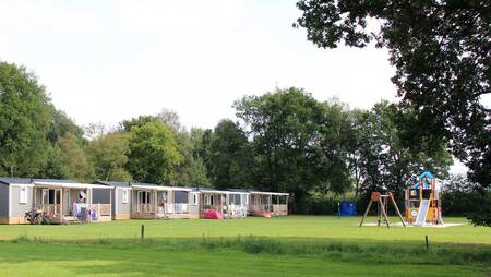 Chalets vom Typ "Pioen" auf einem Feld mit Spielplatz im Ferienpark Molecaten Park 't Hout