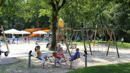 Kinder spielen auf einem großen Spielplatz im Ferienpark Molecaten Park 't Hout