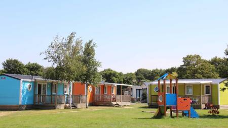 Chalets vom Typ "Zomerzon" auf einem Feld mit Spielplatz im Ferienpark Molecaten Waterbos