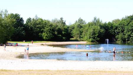 Kinder am Strand und im Wasser des Freizeitsees im Ferienpark Molecaten het Landschap