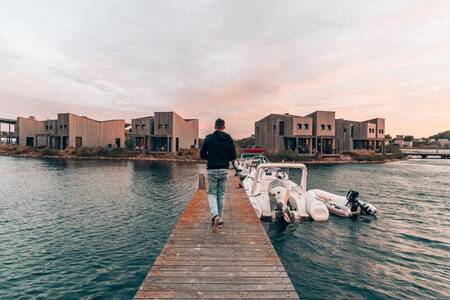 Mann geht vorbei an Booten an einem Steg im Ferienpark Oasisparcs Oasis Punt West