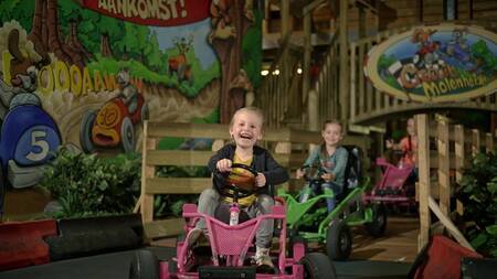Kinder auf Gokarts im Indoor-Spielplatz „Kids Valley“ im Ferienpark Park Molenheide