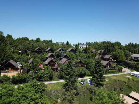 Ferienhäuser zwischen den Bäumen im Ferienpark Petite Suisse in den belgischen Ardennen