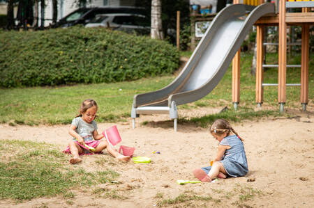 2 Mädchen spielen auf einem Spielplatz im Ferienpark Petite Suisse im Sand
