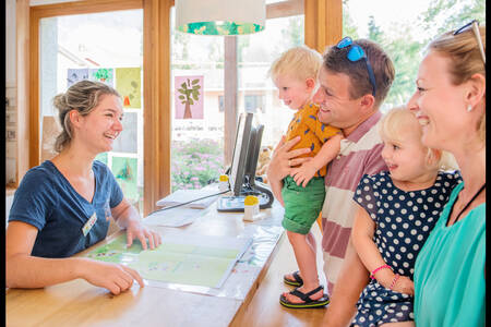 Familie an der Rezeption des Ferienparks RCN Belledonne