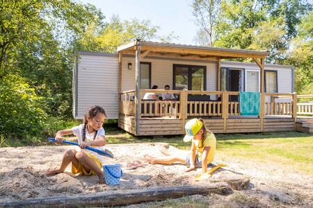 Kinder spielen in einem Sandkasten in einem Chalet im Ferienpark RCN De Noordster