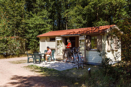 Die Familie entspannt sich im Garten eines Chalets im Ferienpark RCN De Noordster