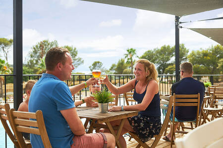 Familie sitzt auf der Terrasse des Restaurants im Ferienpark RCN Domaine de la Noguière