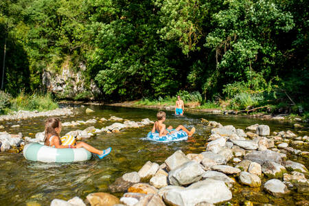 Kinder spielen im Fluss Dourbie neben dem Ferienpark RCN Val de Cantobre