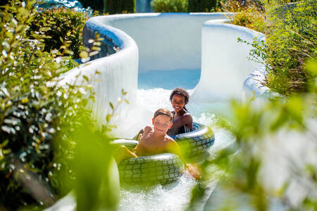 Kinder auf Gummireifen im Wildwasserparcours im Ferienpark RCN Val de Cantobre