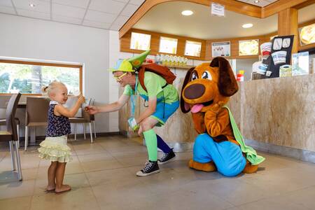 Max & Sammy geben einem Kind in der Snackbar im Ferienpark RCN de Flaasbloem ein Eis