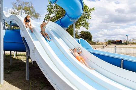 Kinder auf der Wasserrutsche, die im Ferienpark RCN de Flaasbloem im See endet