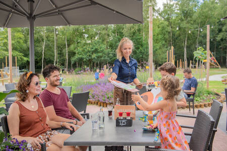 Familie auf der Terrasse des Restaurants im Ferienpark RCN de Jagerstee