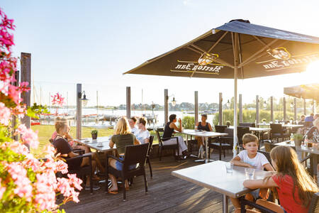 Menschen auf der Terrasse der Brasserie im Ferienpark RCN de Potten