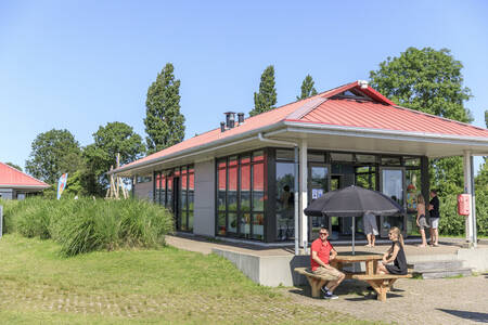 Menschen auf der Terrasse der Snackbar im Ferienpark RCN de Potten