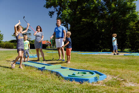 Familie beim Golfspielen auf dem Minigolfplatz des Ferienparks RCN de Potten