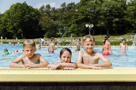 Menschen schwimmen im Außenpool des Ferienparks RCN de Roggeberg