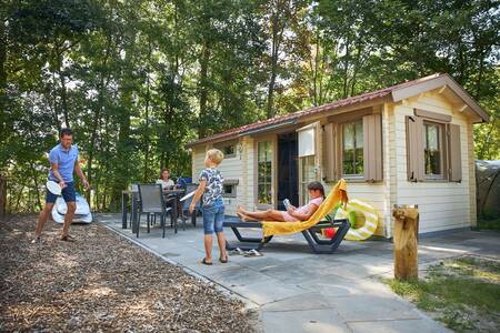 Familie im Garten eines Chalets im Ferienpark RCN de Schotsman