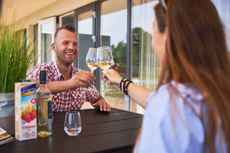 Paar am Tisch im Garten eines Ferienhauses im Ferienpark RCN de Schotsman