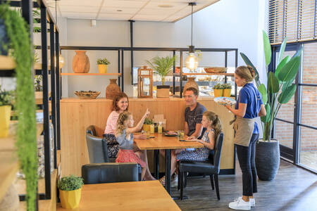 Familie beim Essen im Restaurant des Ferienparks RCN het Grote Bos