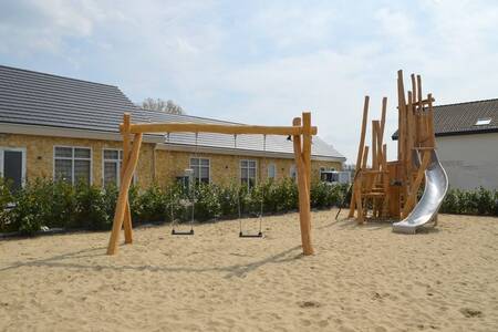 Spielplatz mit Schaukeln und Klettergerüst mit Rutsche im Ferienpark Resort Mooi Bemelen