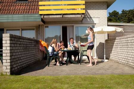 Menschen auf der Terrasse einer Wohnung im Roompot Apartmentkomplex Bosch en Zee
