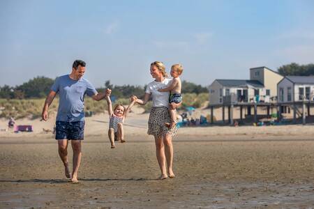 Familie am Strand und Strandhäuser des Ferienparks Roompot Beach Resort
