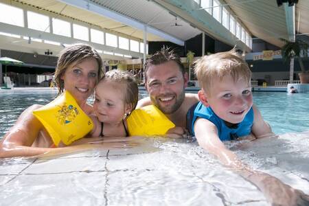 Eine Familie schwimmt im Hallenbad des Ferienparks Roompot Beach Resort
