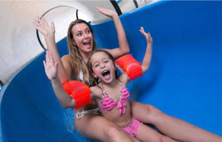 Mutter und Tochter auf der großen Wasserrutsche im Swimmingpool des Roompot Beach Resort