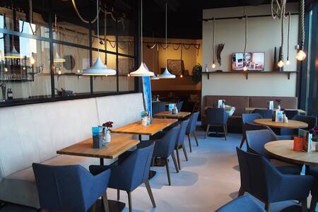 Tische mit Stühlen im attraktiven Restaurant von Roompot Bloemendaal aan Zee