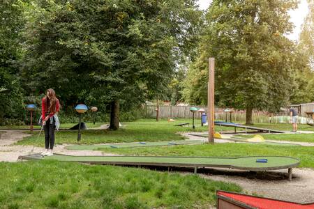 Frau auf dem Minigolfplatz im Ferienpark Roompot Bospark Lunsbergen