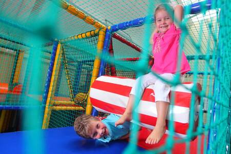 Kinder spielen auf dem Indoor-Spielplatz des Ferienparks Roompot Bospark de Schaapskooi