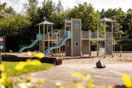 Große Spielgeräte aus Holz auf einem Spielplatz im Ferienpark Roompot Bospark de Schaapskooi