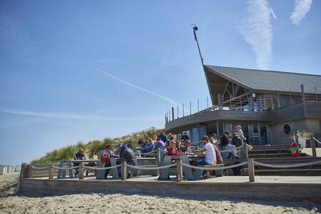 Menschen auf der Terrasse einer Strandbar in der Nähe des Ferienparks Roompot Breeduyn Village