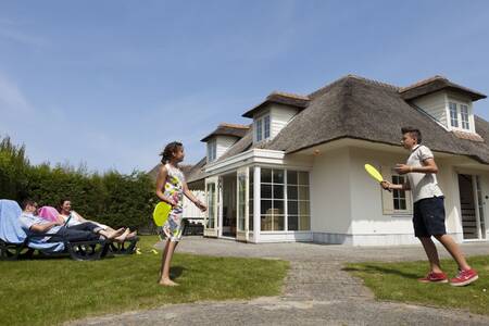 Familie im Garten eines Ferienhauses mit Reetdach im Ferienpark Buitenhof Domburg